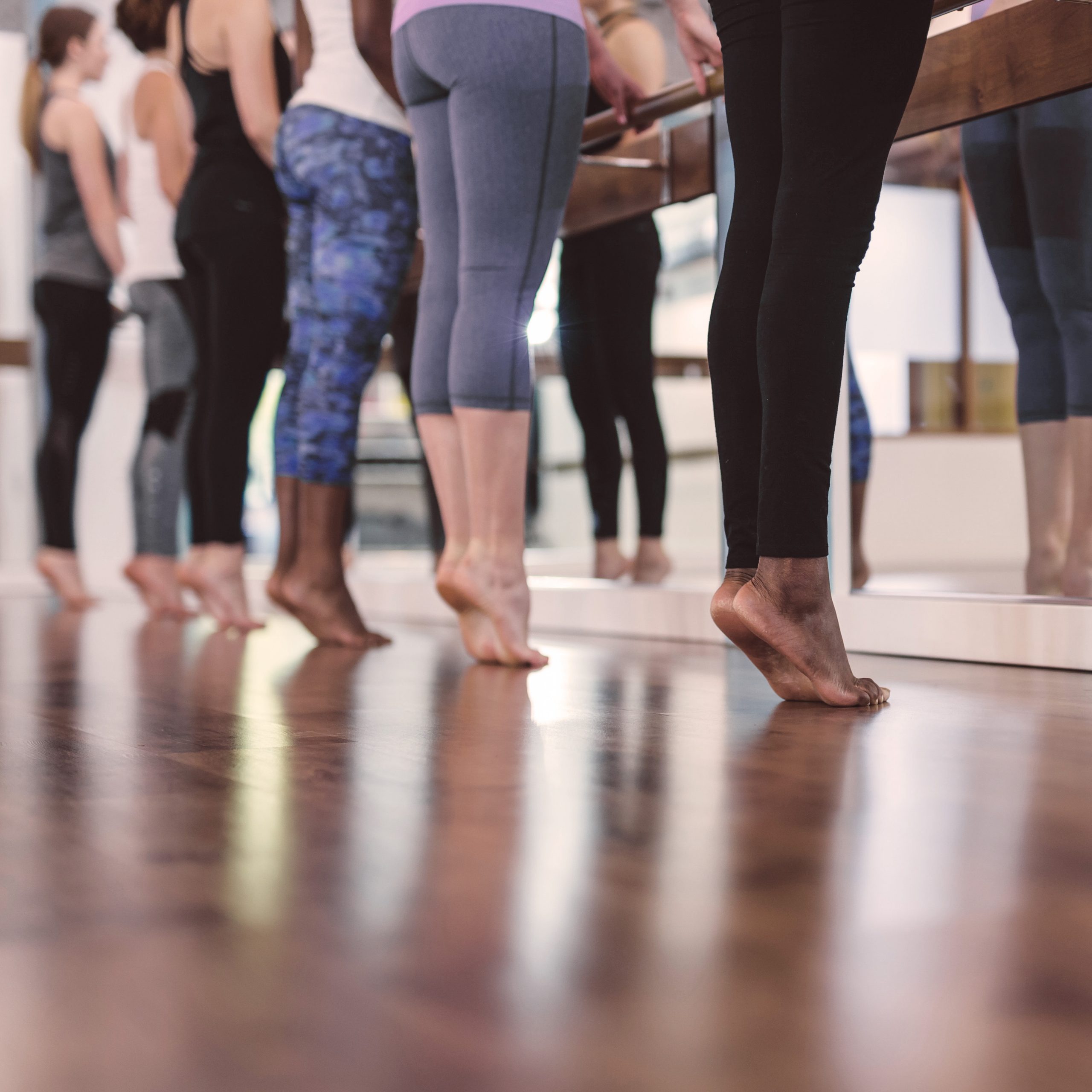 Multiethnic group of women do a barre workout together in a modern health club Spa Mirbeau Barre Generic